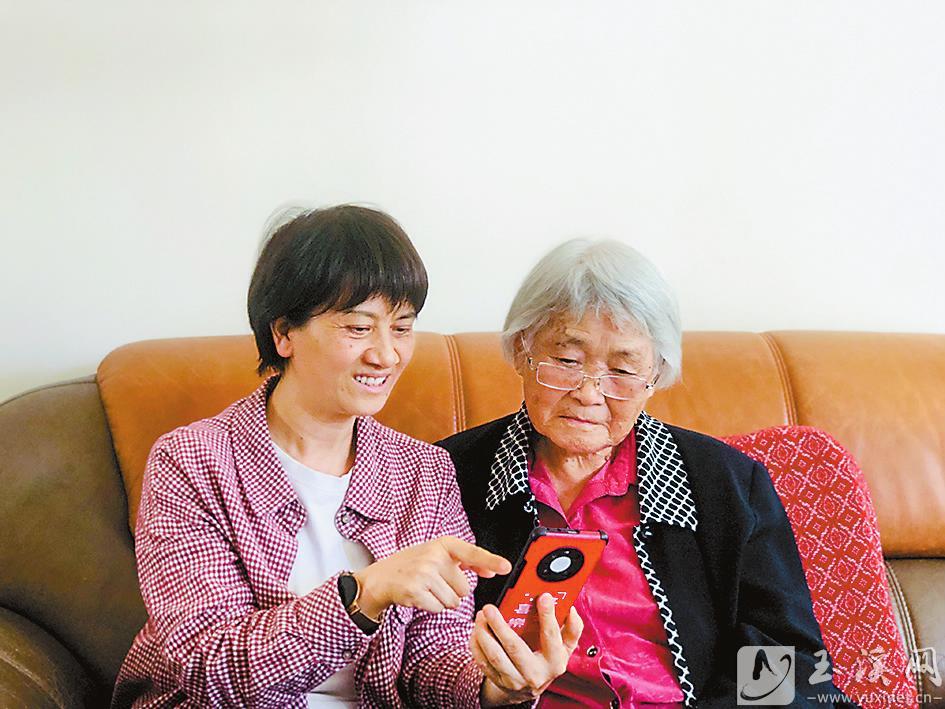 丁樹芬正在給90歲的老同志聶淑芬演示如何使用“學(xué)習(xí)強(qiáng)國”App。 （圖片由丁樹芬提供）