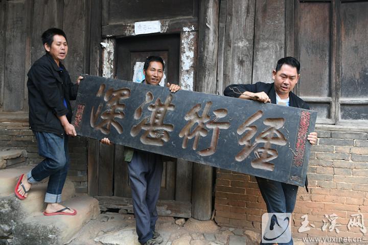 張耀文向游客展示自家珍藏的匾額。