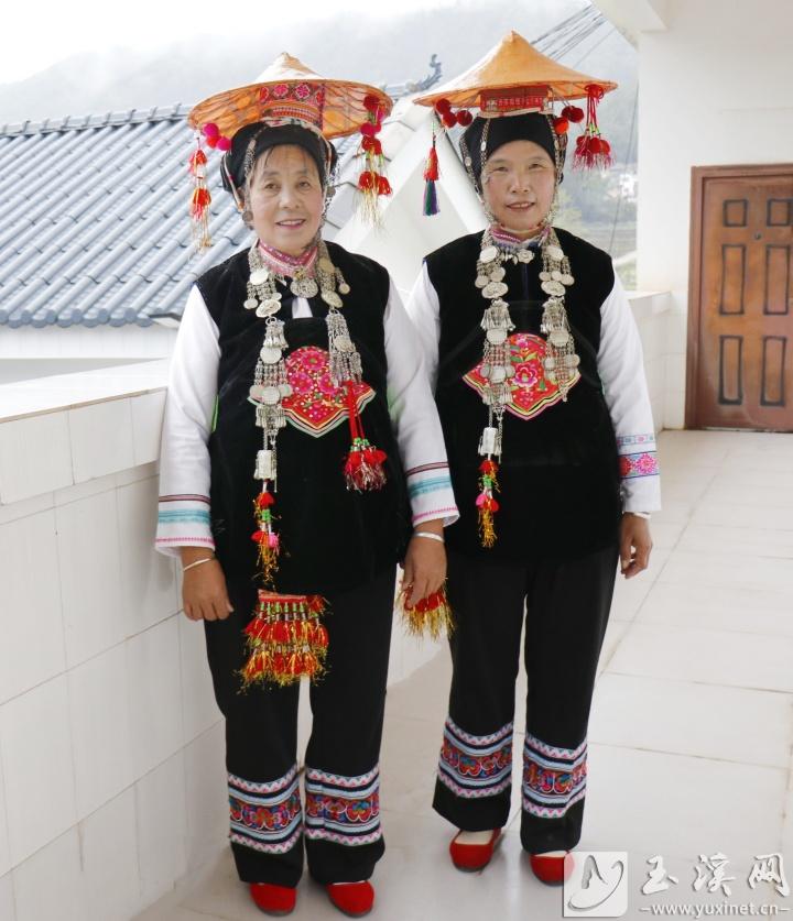 頭戴小葉蓮帽，內(nèi)穿白色長袖衫，外著黑色對襟小褂的彝族婦女。