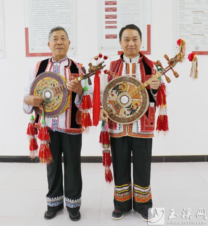 彝家男子身穿民族服飾彈四弦。
