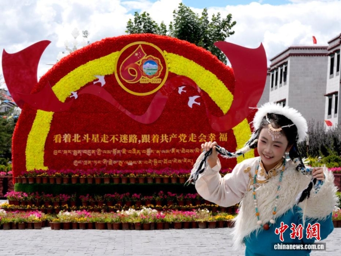 8月19日，隨著西藏自治區(qū)成立60周年慶祝活動(dòng)臨近，拉薩氛圍濃。拉薩街頭，處處是張燈結(jié)彩的盛景，洋溢著一派祥和與歡騰的氛圍。圖為游客在拉薩大昭寺廣場(chǎng)上的大慶宣傳標(biāo)語(yǔ)前留念。<a target='_blank' href='/'>中新社</a>記者 李林 攝